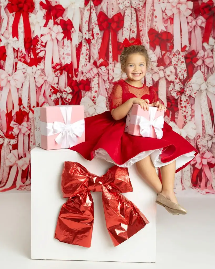 little girl in red dress with gifts – Cream N Cocoa Little girl in a red dress holding Valentine’s gifts at a Cincinnati family photo session.