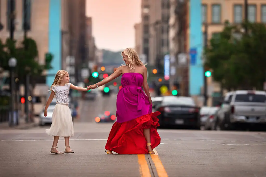 Cincinnati family photographer capturing mother and daughter walking together in downtown city street