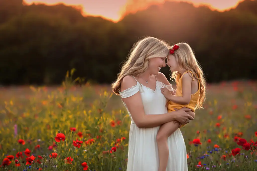 mother and daughter embracing in golden field during sunset family photography session Cincinnati