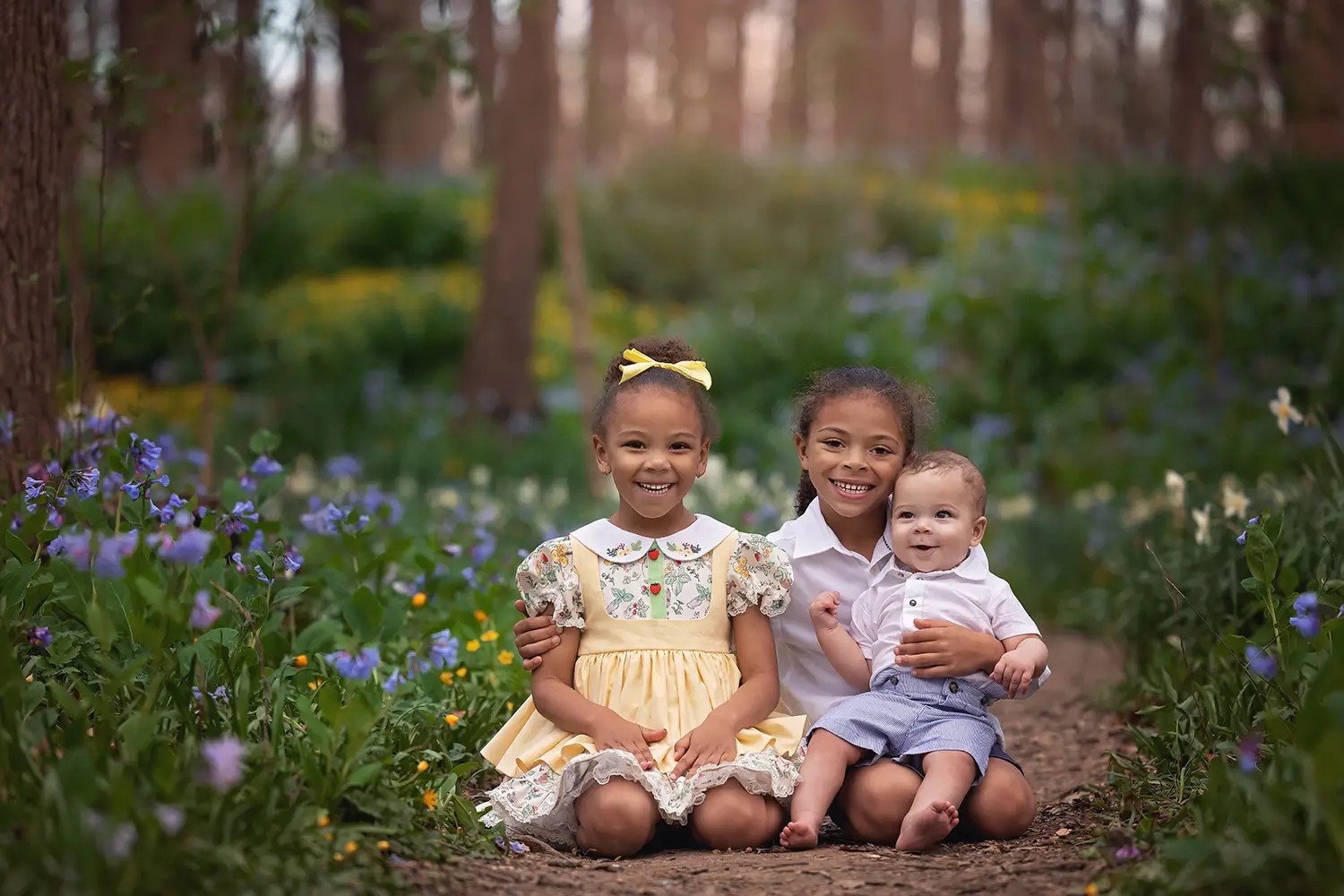 Cincinnati newborn and family photographer capturing siblings holding baby in outdoor setting