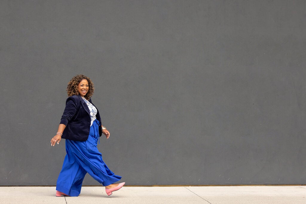 Confident female entrepreneur walking in blue pants during a Cincinnati brand photography session