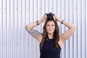Professional personal branding portrait for Cream n Cocoa featuring a Cincinnati brand photographer holding a Canon camera against a modern textured backdrop. This image supports small business branding, website marketing, and visual storytelling for entrepreneurs in Cincinnati.
